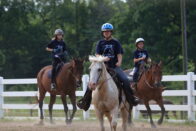 Campers ride their horses