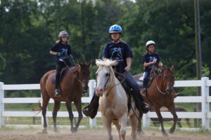 Campers ride their horses