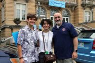 A student with her family poses in front of Le Fer