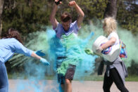 Student running through cloud of color