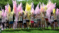 students throwing powder in the air during color run