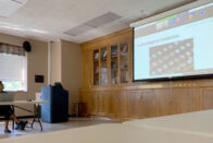 Reed watching the women's conference on a screen