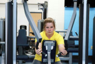 A student working out on a machine in Club 64