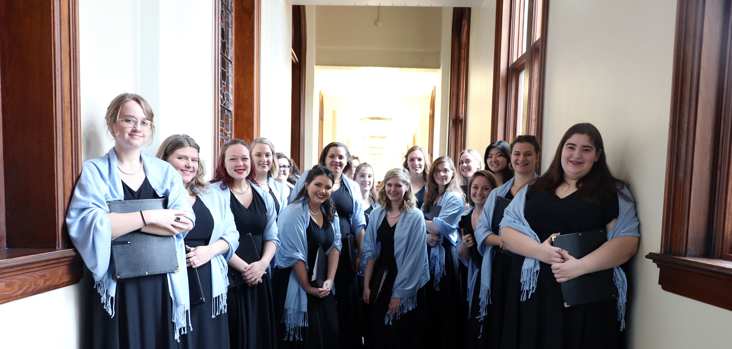 Choir students smile for a group picture before a concert