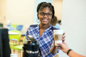Student getting a coffee from the woods student center