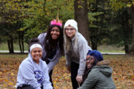 Diverse group of students show off a newly planted tree