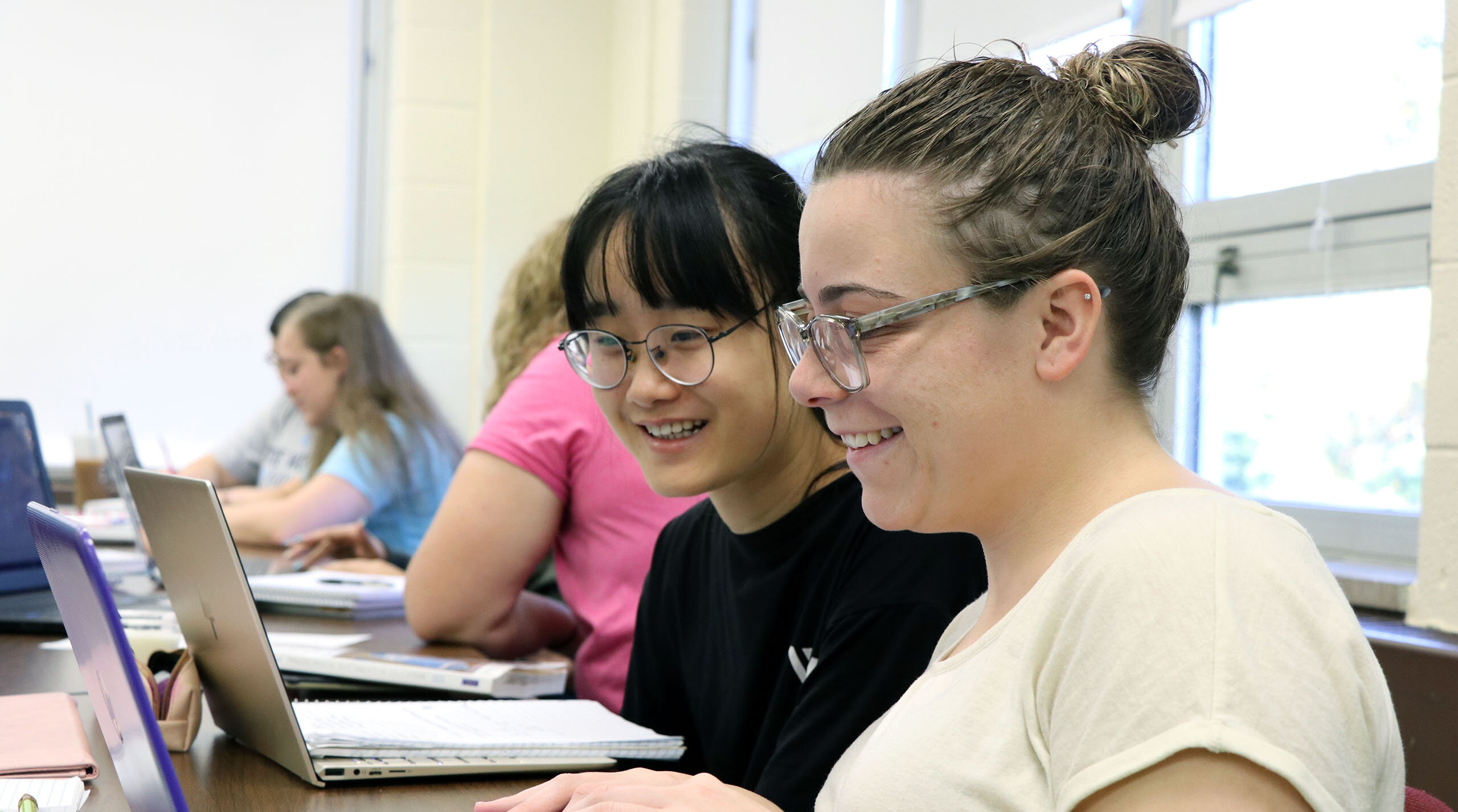 Students smiling and working in class