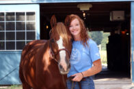 A smiling student with a horse