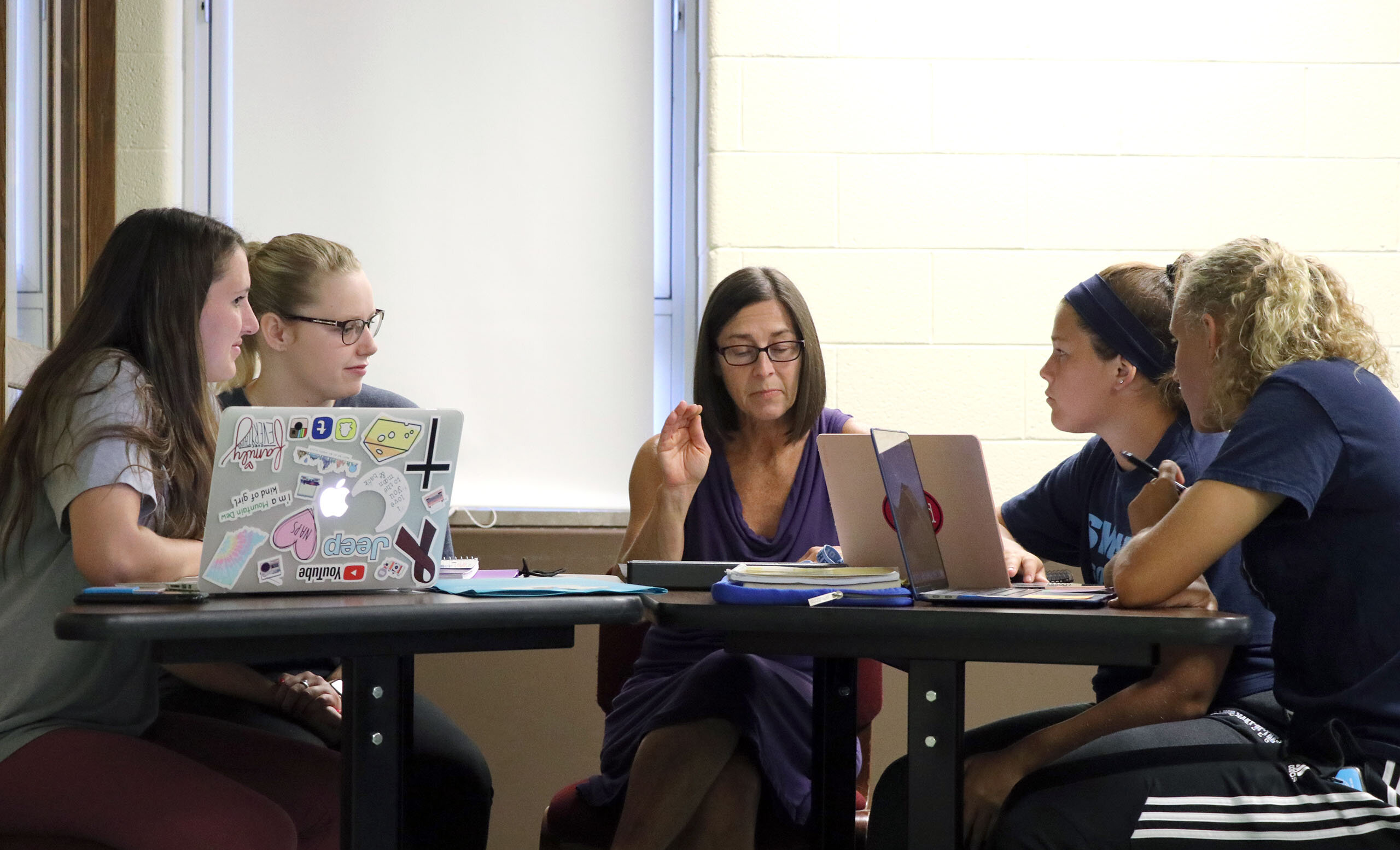 Four students meeting with a professor