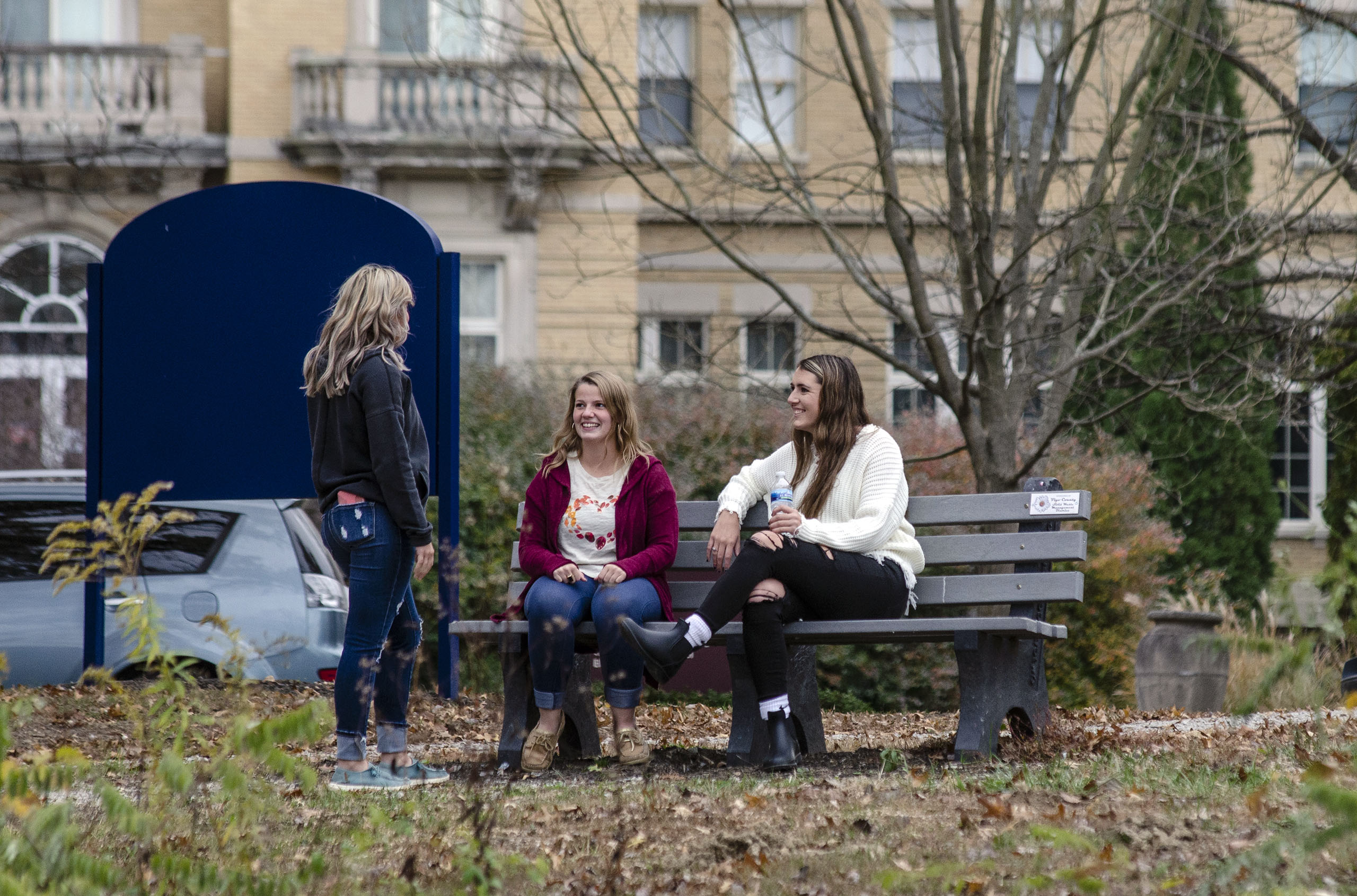 Students on a bench in front of Le Fer Hall