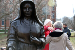 People walking together behind the SMTG Statue