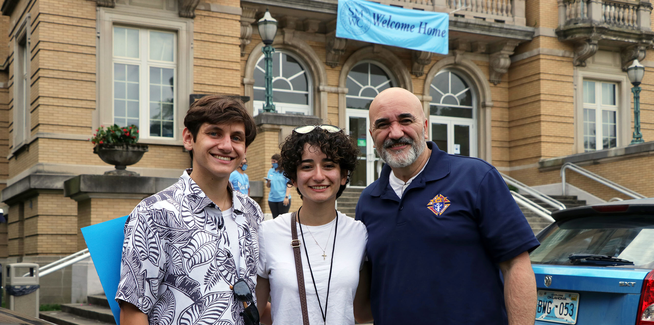 A student with her family poses in front of Le Fer