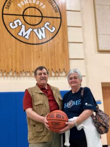Morg and Nancy holding a basketball in the Knorele Center