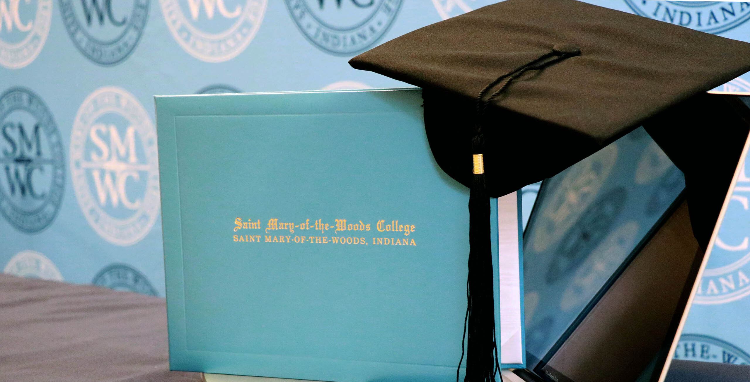 SMWC diploma and cap sitting on a laptop