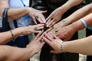 Alums putting their hands together with Woods Rings at Reunion