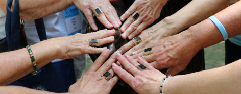 Alums putting their hands together with Woods Rings at Reunion