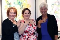 Alumni and student showing their rings
