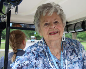 Frankie Supplitt Kramer riding in a golf cart