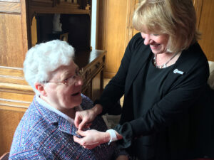 President Dottie King placing pin on Sister Martine Meuwissen