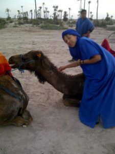 Debra Powell kneeling next to camel
