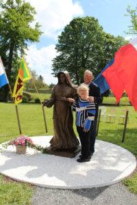 Mary Ann and Jerry Hellmann standing with the Saint Mother Theodore Guerin statue