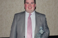 AJ Dinkel holding his top 12 under 40 award
