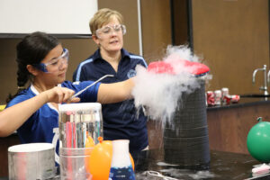 Janet Clark working with student in chemistry workshop