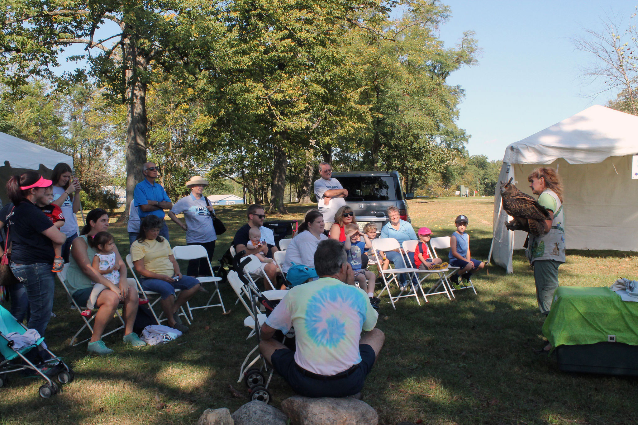 A crowd watches as a large owl is presented at the Silly Safari