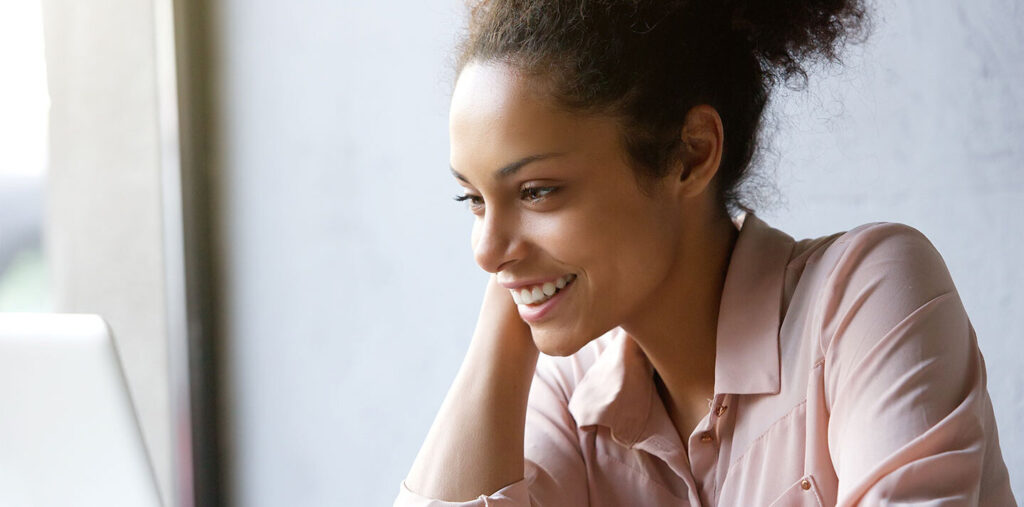 Woman looking at laptop and smiling