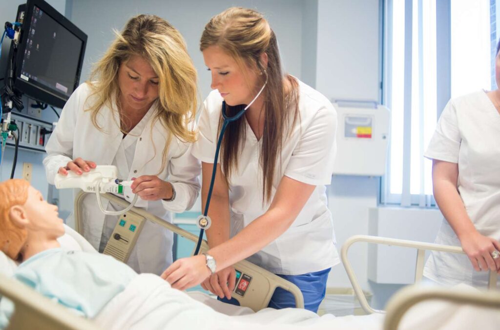 Two nursing students take the temperature of a child.