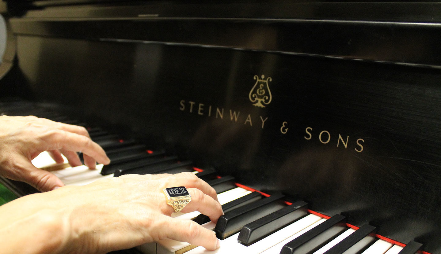 Hands wearing Woods ring playing Steinway piano