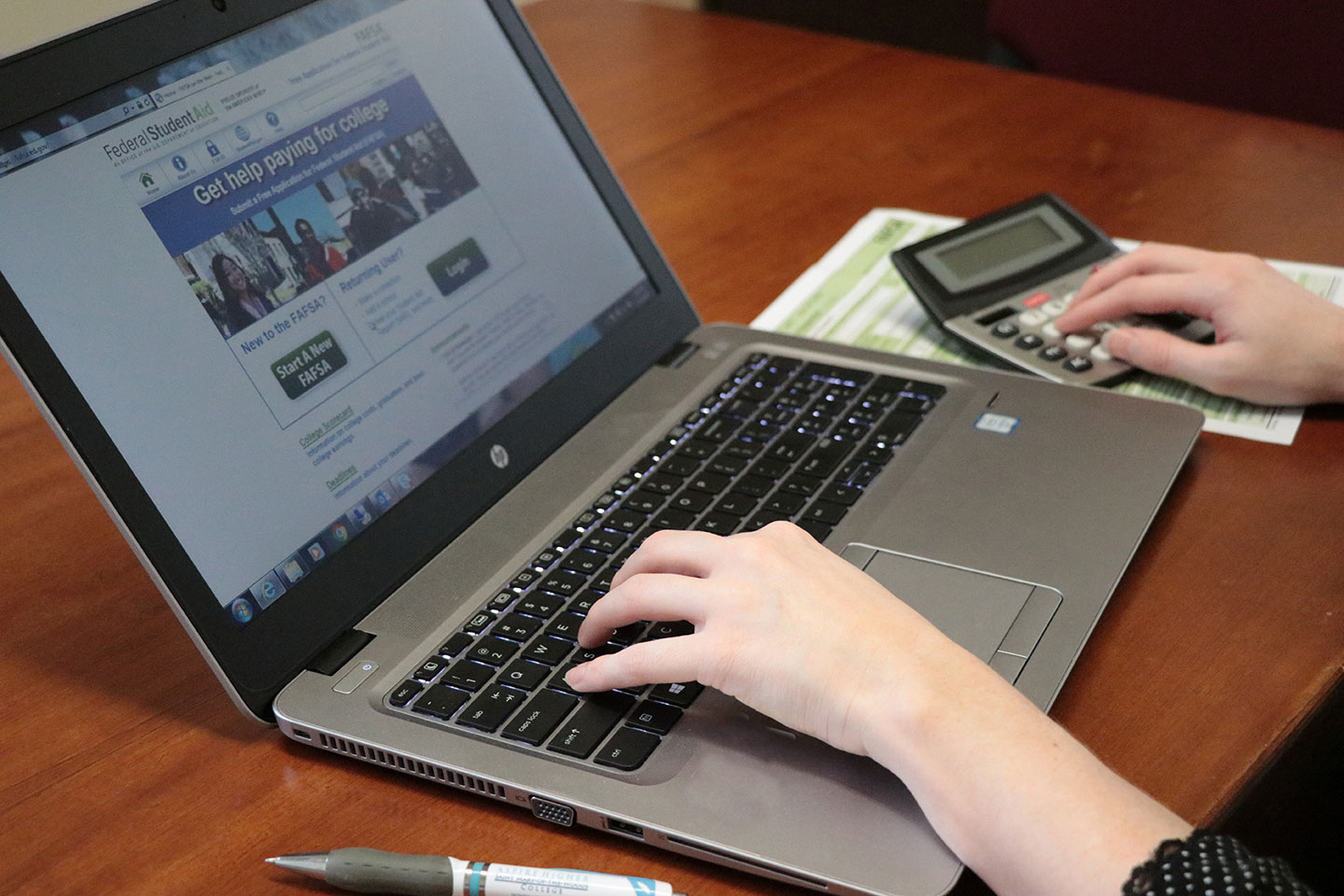 Person browsing financial aid site on laptop