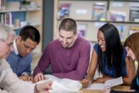 Adult students at a table studying together.