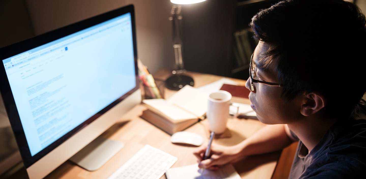 WOL asian guy studying at desk with computer