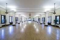 The beautiful, large Le Fer Hall Ballroom with the chandeliers, columns and wood floors.