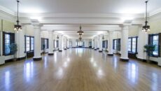 The beautiful, large Le Fer Hall Ballroom with the chandeliers, columns and wood floors.