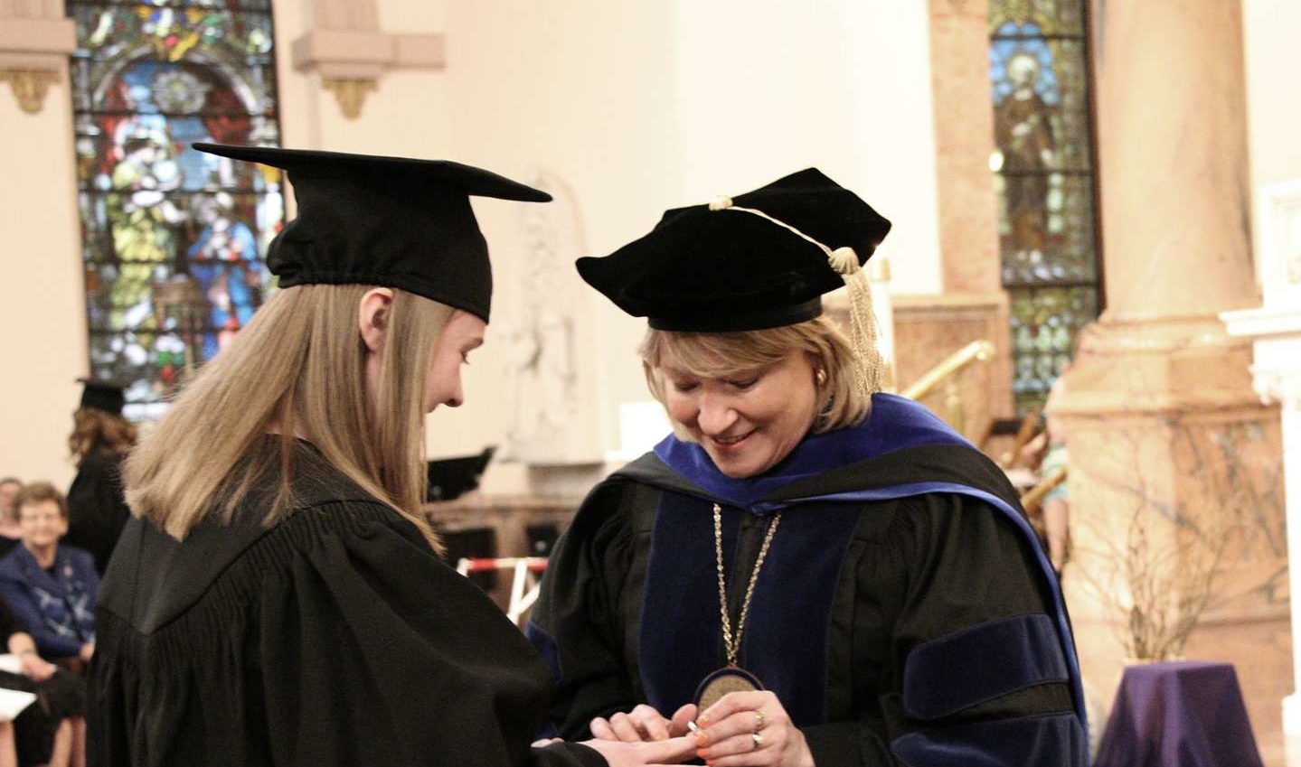 President Dottie King puts a Woods Ring on a student's finger.