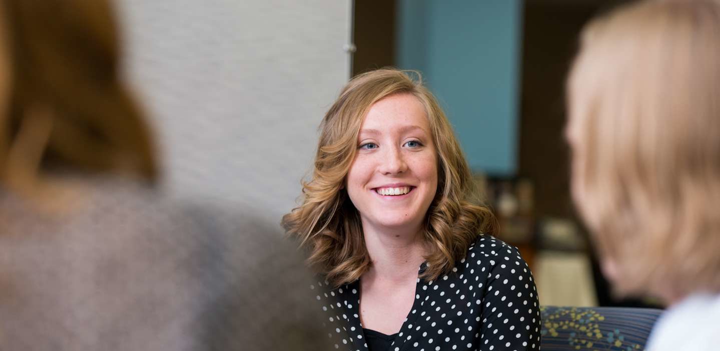 A female student in a group setting smiling.
