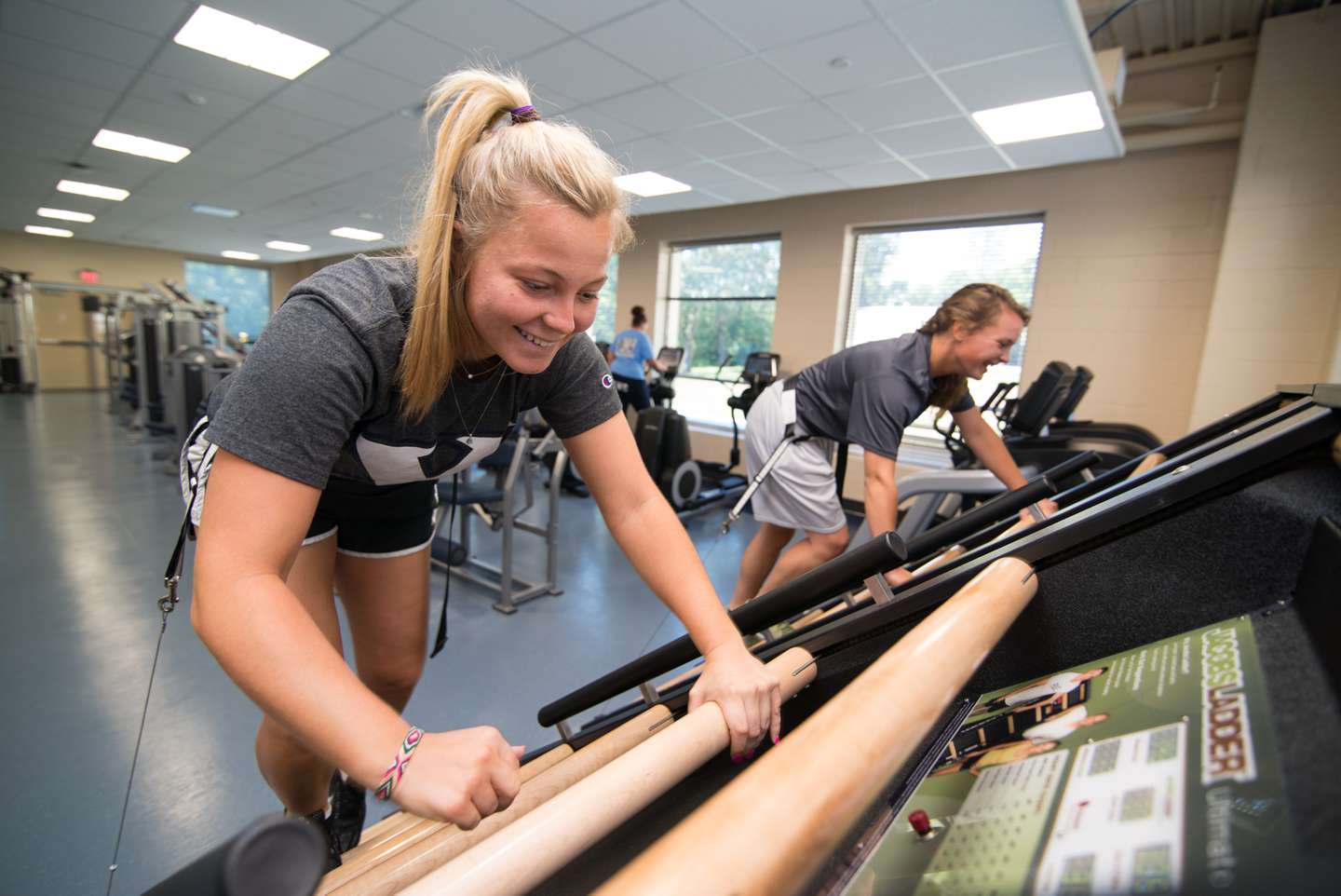 Two female students work out together in the fitness center.