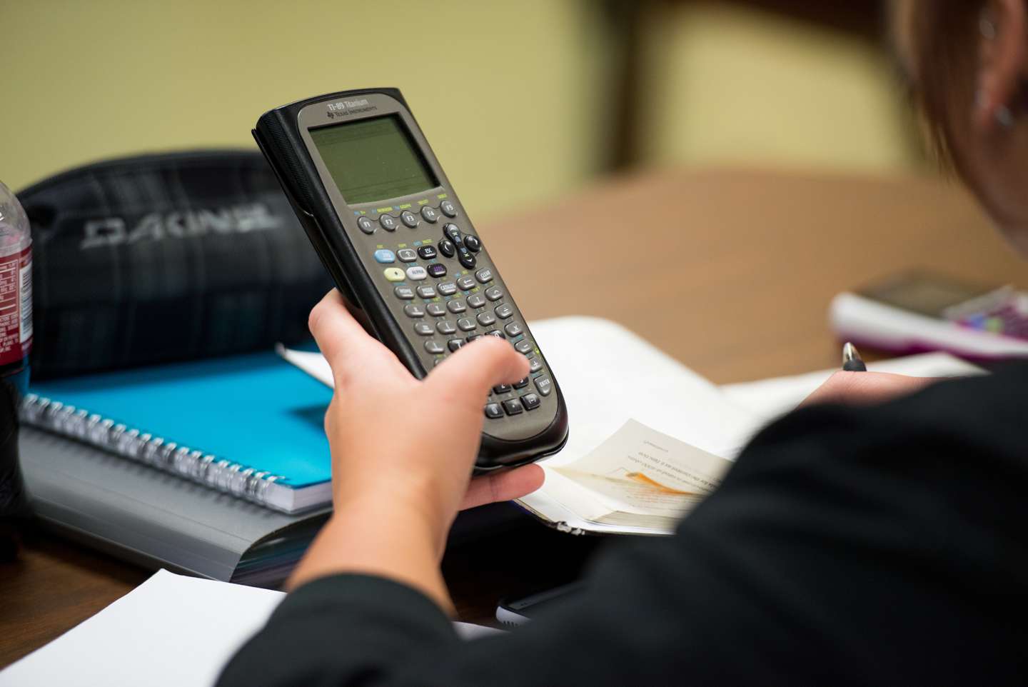 A student holds a graphing calculator.