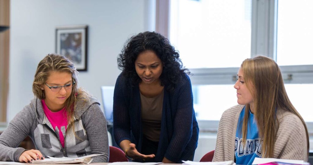 An instructor explaining a lesson to two students.