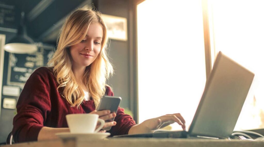 A young woman with a laptop and phone.