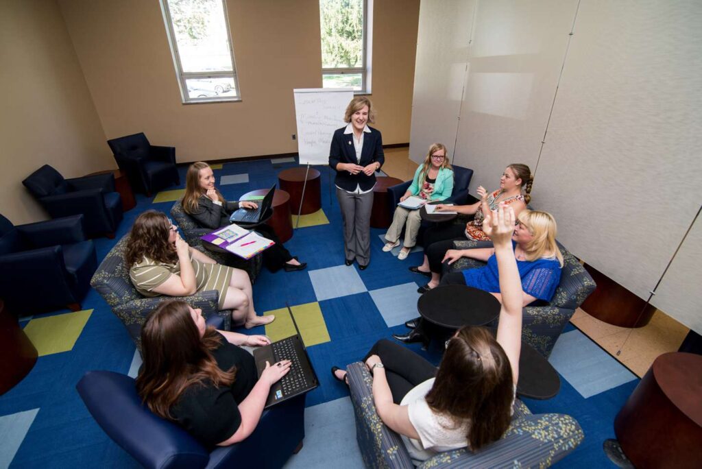 A group of female students in a circle having a business meeting.