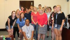 A group of SMWC students smiling with President Dottie King in her office.