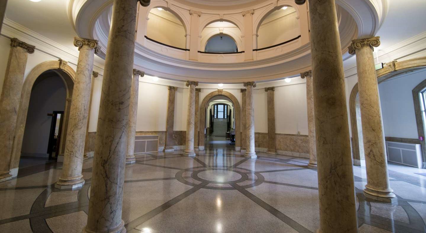 The beautiful Rotunda with large marble columns and a view of the circular arches on the second floor.