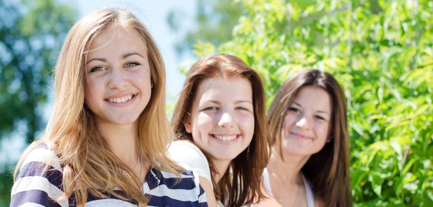 Three female students smiling.