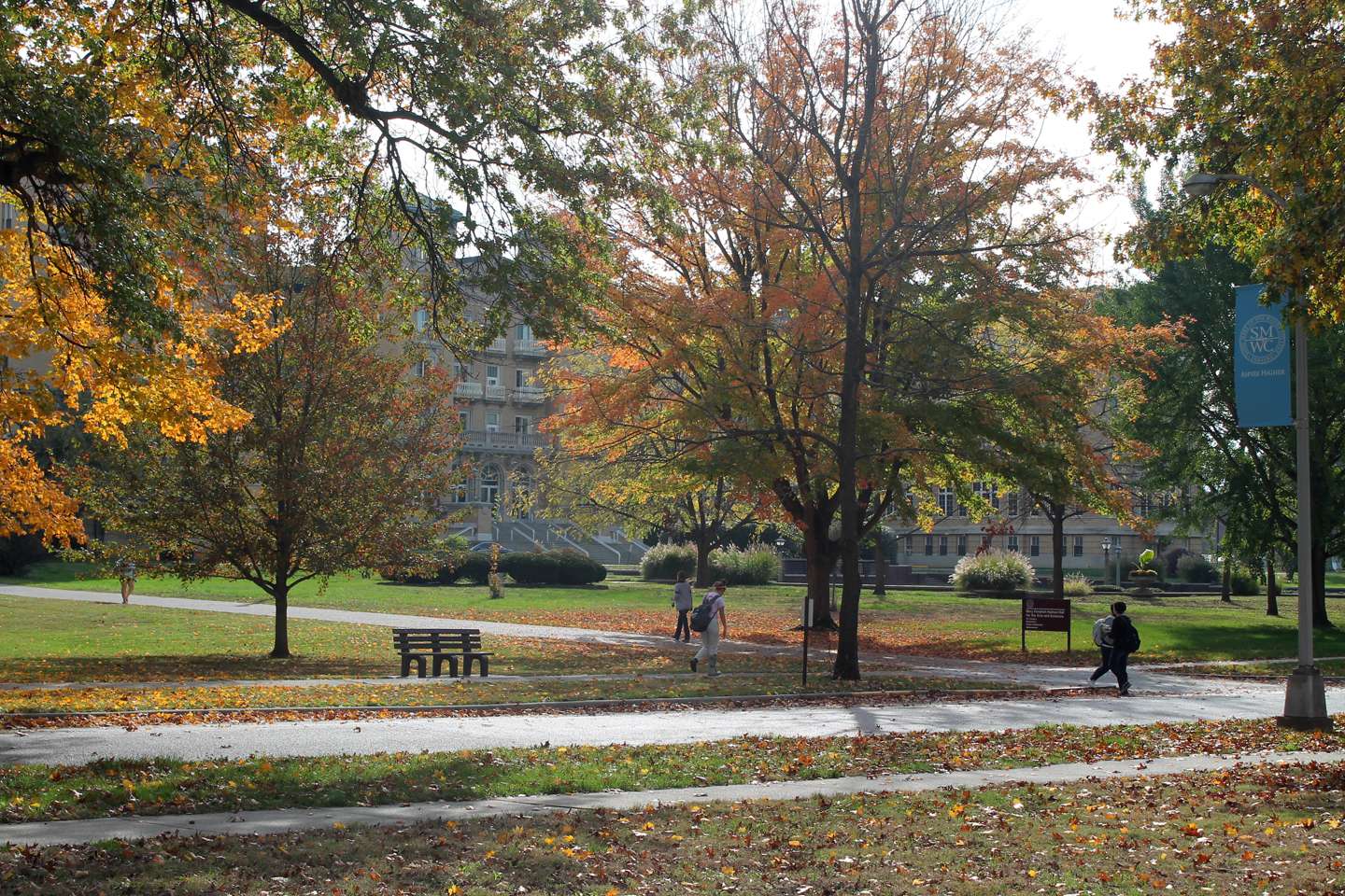 Students walking across campus on a fall day.